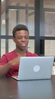 İş yerindeki laptopta günlük Afrikalı Adam Video Sohbeti yaparken çekilen dikey video