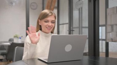 Dizüstü bilgisayarla video sohbeti yapan yaratıcı genç kadın.