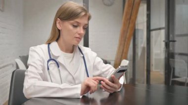 Genç Kadın Doktor İş yerinde Telefonu Kullanıyor