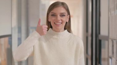 Başparmakları havada genç bir kadının portresi Kameraya bakıyor