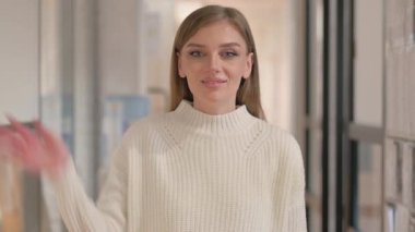 Merhaba demek için el sallayan genç kadının portresi.