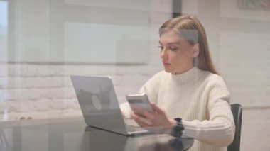 Kadın Çalışan Dizüstü bilgisayarlı Telefonu Kullanıyor