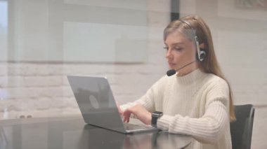 Dizüstü bilgisayarda çalışan Kadın Müşteri Hizmetleri Temsilcisi