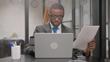 Afrika işadamı belgeleri ve Laptop üzerinde çalışma