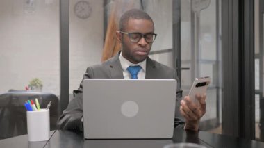 Afrikalı İşadamı Laptop ile Telefonu Kullanıyor