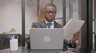 Belgeler ve Laptop Üzerinde Çalışan Afrikalı İş Adamı Heyecanlı