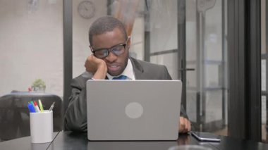Dizüstü bilgisayar üzerinde çalışırken uyuyan Afrikalı İşadamı