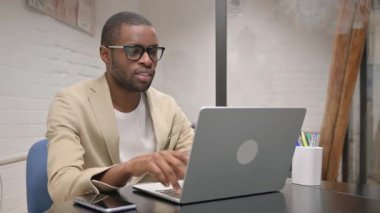 Dizüstü bilgisayarla uğraşan Afrikalı Adam