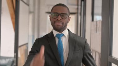 Başparmakları havada Afrikalı iş adamının portresi Kameraya bakıyor