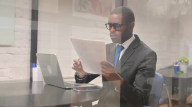 Belgeler ve Laptop Üzerinde Çalışan Afrikalı İş Adamı Heyecanlı