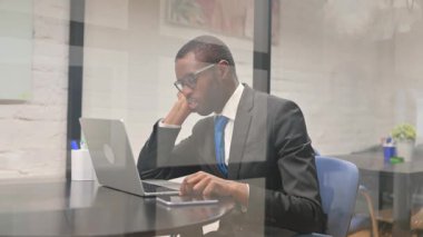 Dizüstü bilgisayar üzerinde çalışırken uyuyan Afrikalı İşadamı