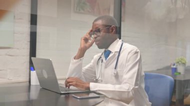 Migreni olan Afrikalı erkek doktor hastanede.