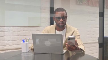 Yetişkin Afrikalı Adam Laptop ile Telefonu Kullanıyor