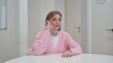 İş kadını müşteriyle telefonda konuşuyor.