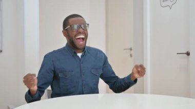 Baş ağrısı olan genç bir Afrikalı iş yerinde oturuyor.