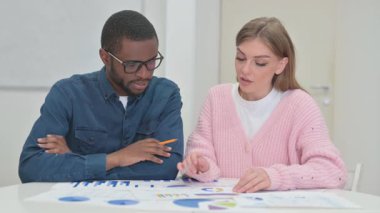 Belgeler üzerinde çalışan genç takım arkadaşlarına yakın çekim