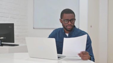 Orta yaşlı Afrikalı Adam Yıllık İş Raporuna Tepki Verdi