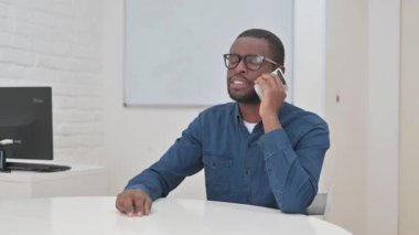 Orta yaşlı Afrikalı Adam Müşteriyle telefonda konuşuyor