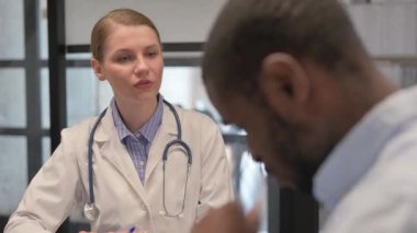 Female Doctor Talking with Patient in Clinic