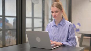 Dizüstü bilgisayarda yazarak meşgul genç kadın