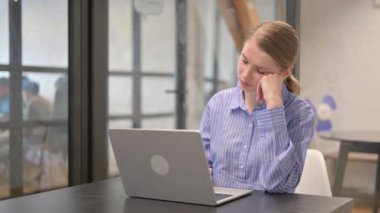 Young Woman Sleeping while Working on Laptop