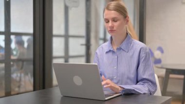 Ofiste kameraya bakan genç bir kadın.