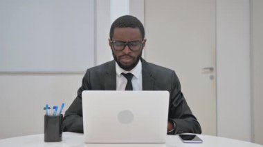 Ciddi bir Afrikalı Amerikalı işadamı modern ofis ortamında onaylamadığını ifade ediyor