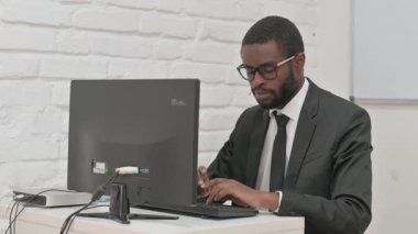 Bilgisayarda çalışırken gülümseyen neşeli iş adamı