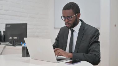 Dizüstü bilgisayarla çalışan Afrikalı Amerikalı iş adamı