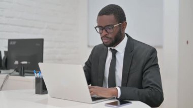 Hevesli Afrikalı Amerikalı iş adamı ofis masasından onay veriyor.