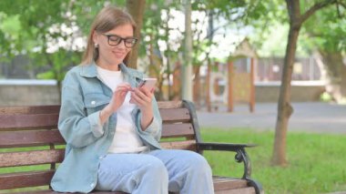 Park Benç 'inde Telefon Kullanan Genç Kadın