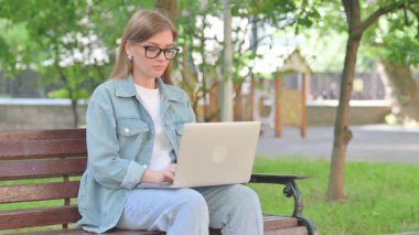 Dizüstü bilgisayarlı Park 'taki Genç Kadın Hareketsiz Gösteriyor