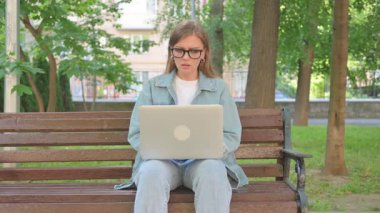 Park 'ta dizüstü bilgisayara tepki veren Stresli Genç Kadın