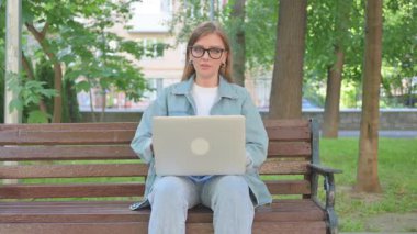 Kadın Dışarıda Otururken Dizüstü bilgisayarla Başparmak Veriyor