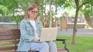 Park 'ta Dizüstü bilgisayar kullanırken Sırt Ağrısı Olan Genç Kadın