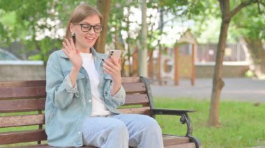 Park Bench 'te Genç Kadın Video Görüşmesi ya da Konferans