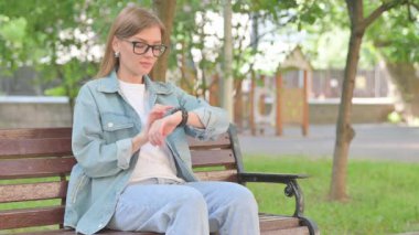 Park Bench 'te bilek kontrolü yapan genç bir kadın.