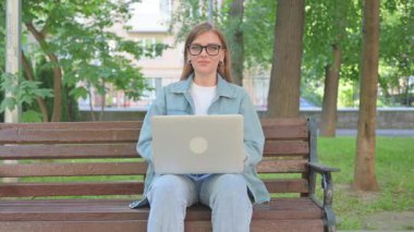 Açık havada otururken Dizüstü bilgisayarından vazgeçen kadın