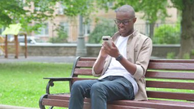Genç Afrikalı Adam Park Benç 'inde Telefon Kullanırken Heyecan Veriyor