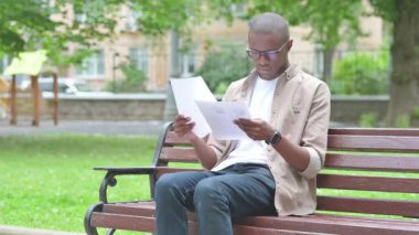 Belgeleri okurken Hayal Kırıcı Genç Afrikalı Adam