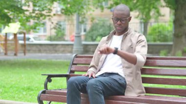 Park Bench 'ten uzaklaşan genç Afrikalı adam bekliyor.