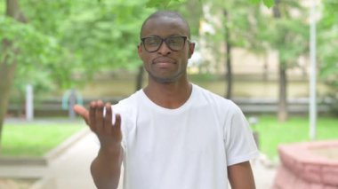 Genç Afrikalı bir adam El ile dışarıda bekliyor.