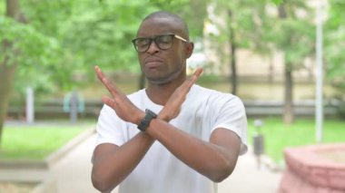 Genç Afrikalı adam dışarıda hareketlerini durduruyor.