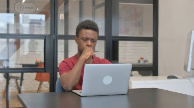 İş yerindeki laptopta sıradan Afrikalı Adam Öksürüyor
