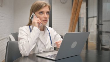 Genç erkek doktor hastanede telefonda konuşuyor