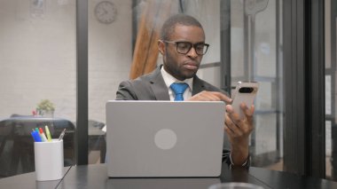 Afrikalı İşadamı Laptop ile Telefonu Kullanıyor