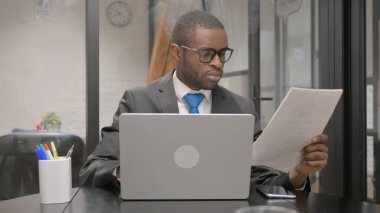 Afrika işadamı belgeleri ve Laptop üzerinde çalışma