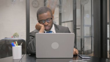 Dizüstü bilgisayar üzerinde çalışırken uyuyan Afrikalı İşadamı