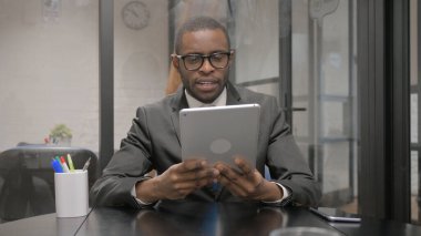 Afrikalı İşadamı Çalışma Alanında Tablet 'te Video Sohbeti Yapıyor