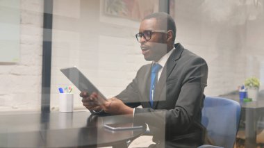 Afrikalı İşadamı Çalışma Alanında Tablet 'te Video Sohbeti Yapıyor